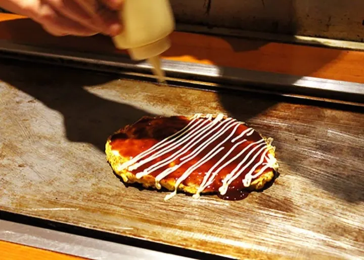 Okonomiyaki griddle-cooked to order at a Grand Front Osaka restaurant.