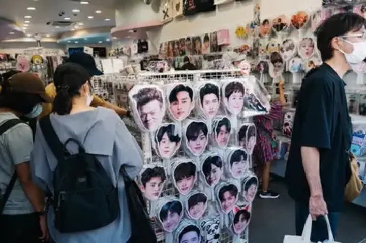 K-pop merchandise — posters, photo cards, and albums — at a Shin-Okubo goods shop.
