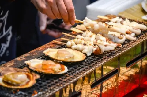 Grilled seafood cooked to order at a market stall.
