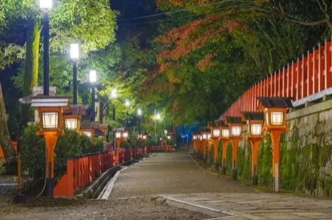 Yasaka Shrine lit by lanterns at night.
