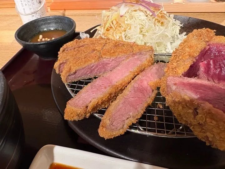 A close-up of the sirloin cutlet, breaded and fried to a golden crust.