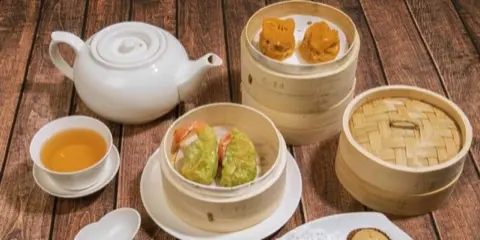 Dim sum steamers served with tea.