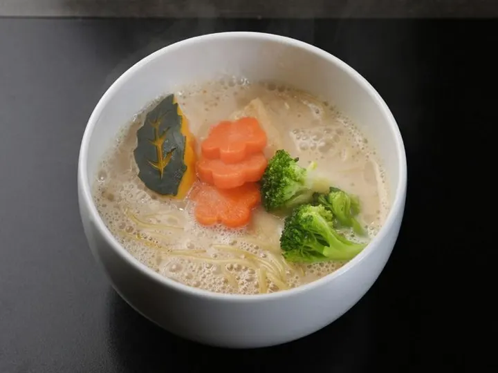 A clear salt-broth ramen at ISSUN BOUSHI, topped with carrot, broccoli, and kabocha squash.