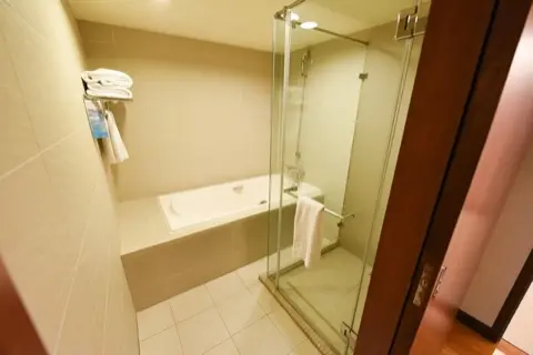 Bathroom with soaking tub and glass-enclosed shower.