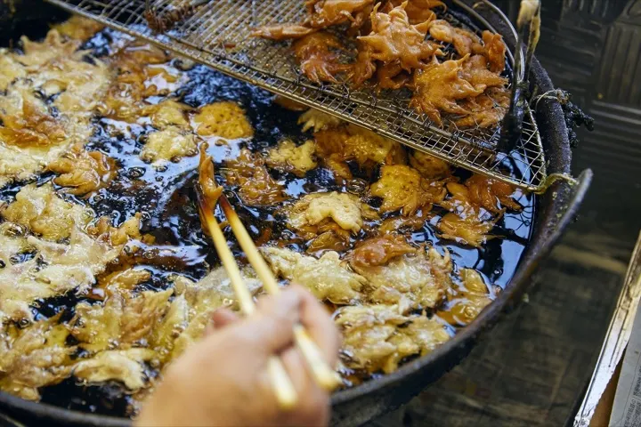 Deep-frying the salt-pickled maple leaves in oil.