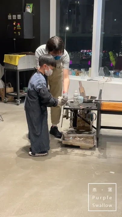 A parent helping a child during the hands-on shaping step at the workbench.