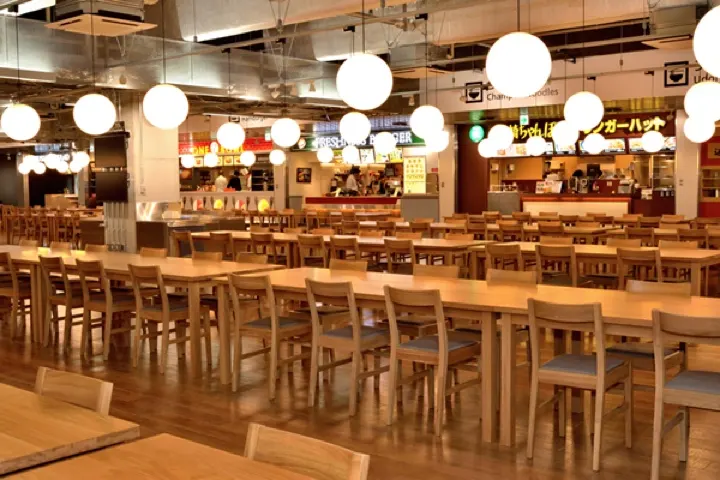 Terminal 3's food court, seating 400+ with low-cost natural-wood Muji furniture.