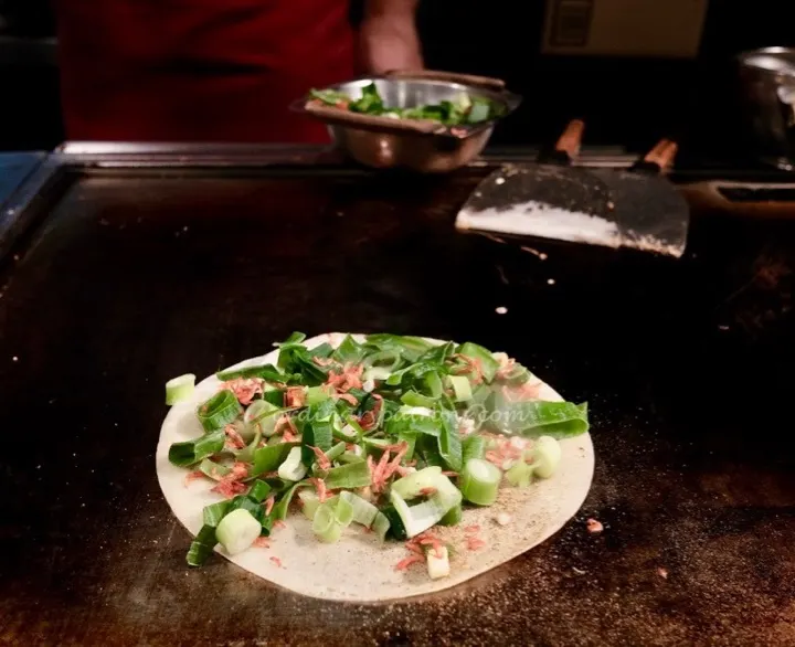 Okonomiyaki cooking on the grill at Chibo, an Osaka okonomiyaki specialist.