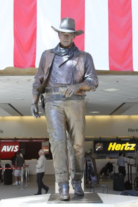 The nine-foot bronze John Wayne statue in the Thomas F. Riley Terminal's arrival level.