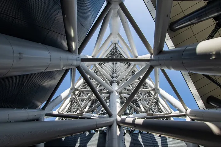 The white steel lattice framework of the tower, seen from below.