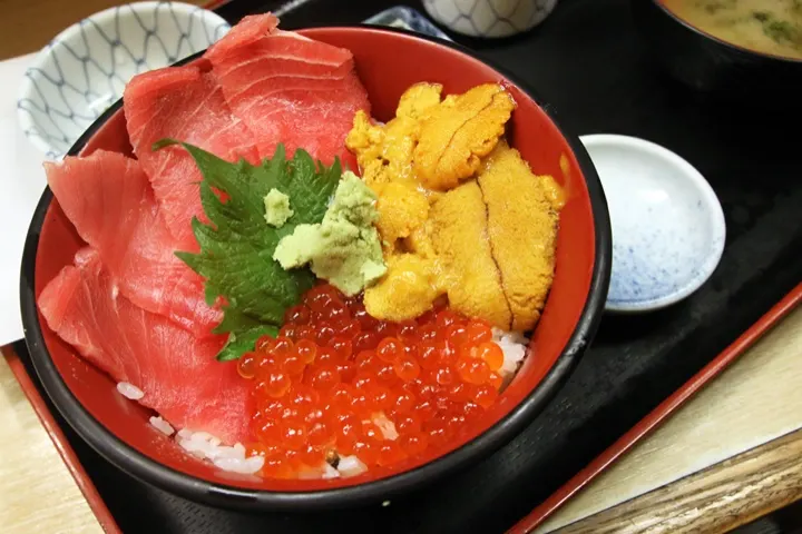 A kaisendon seafood rice bowl with tuna, uni, and ikura — a classic way to start a morning at the market.