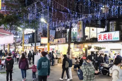 Street scene amid fashion boutiques and signage.