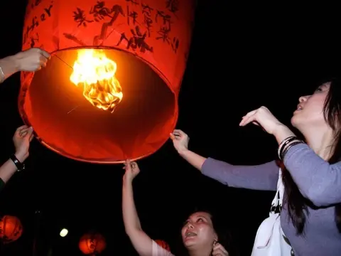 Releasing a wish-covered sky lantern.